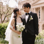 Wedding couple standing outdoors with a building in the background
