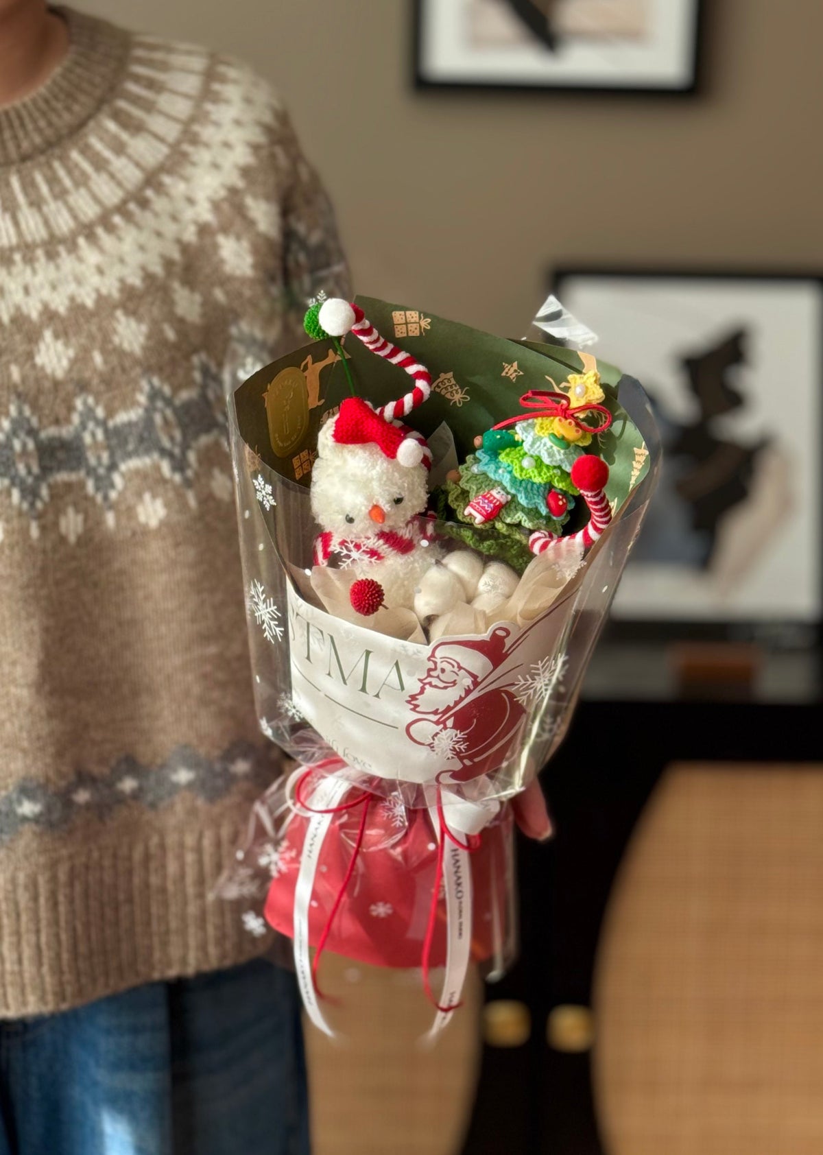 Bouquet with decorative items including a snowman and candy cane in a clear wrap.