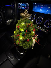 Decorative wreath with lights on a car dashboard.floral christmas tree